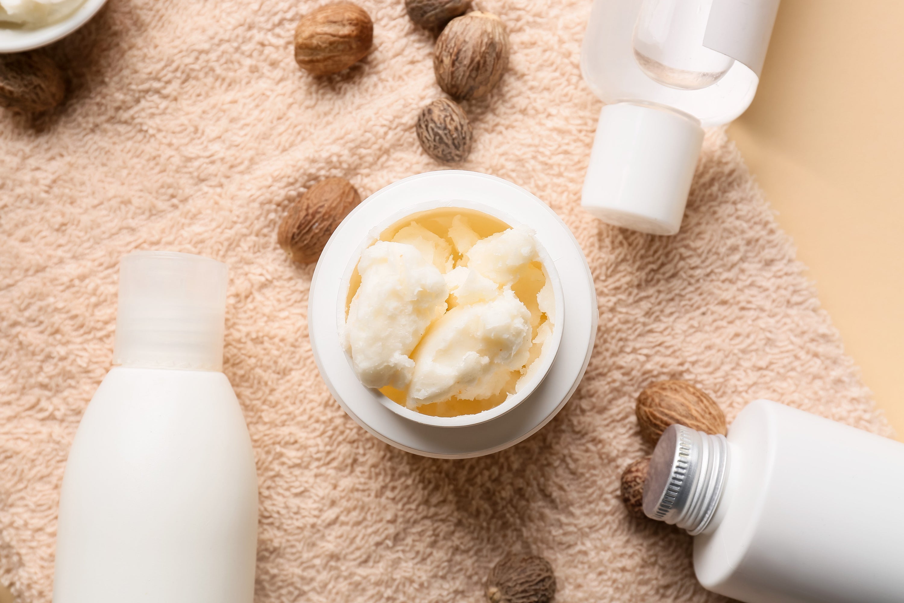 jar of shea butter cosmetic products and brown towel background